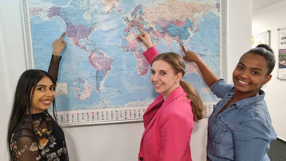 Studierende vor Weltkarte an der International School of Management